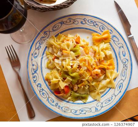 Close up of tasty warm pasta with seafood at plate on table Close up of tasty warm pasta with seafood at plate on table 126374907