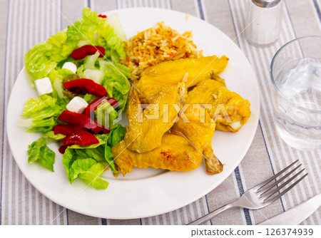 Appetizing chicken wings with rice and a vegetable salad 126374939