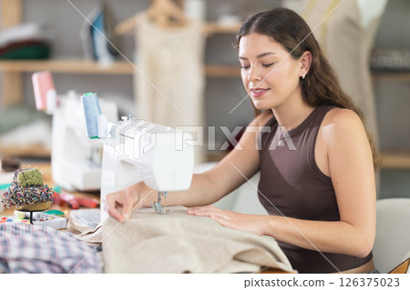 Female fashion designer sewing to order in the workshop Female fashion designer sewing to order in the workshop 126375023