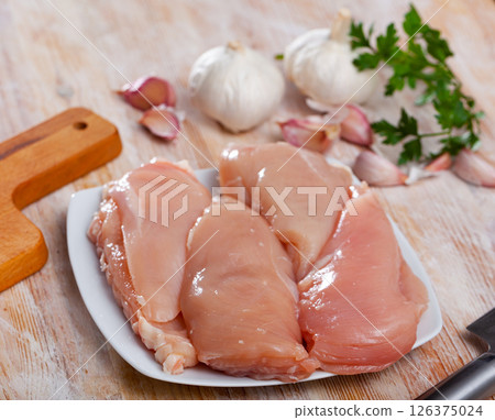 Uncooked raw chicken breast fillet with parsley and garlic Uncooked raw chicken breast fillet with parsley and garlic 126375024