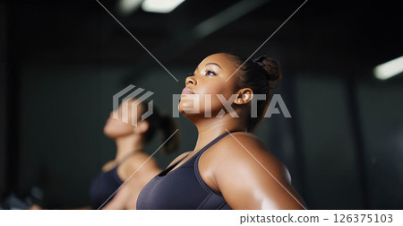 Plus size woman lifting dumbbells and training indoors at the gym, showcasing strength and determination. Generated image 126375103