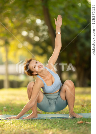 Adult woman doing yoga in garland pose 126375135