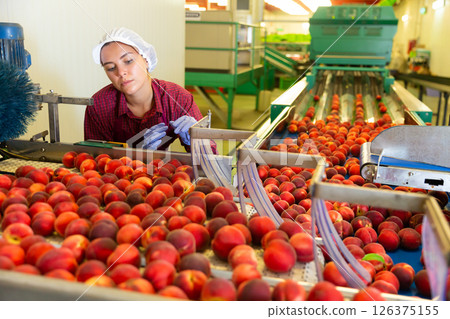 Young woman standing beside conveyor 126375155
