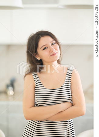 Young smiling woman in kitchen 126375288