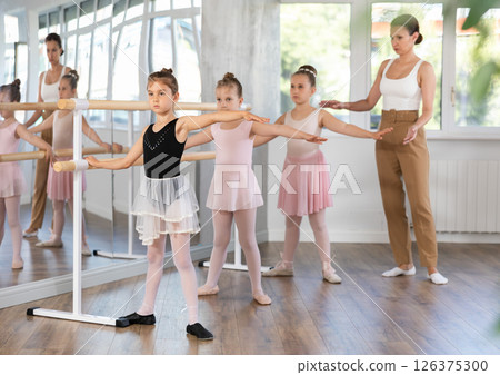 Little girls at the barre learning to get into second position of ballet choreography 126375300