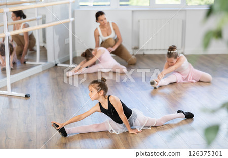 Group of girls doing splits in studio Group of girls doing splits in studio 126375301