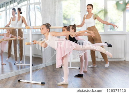 Little girls ballet lovers learn to perform arabesque pose in choreography studio 126375310