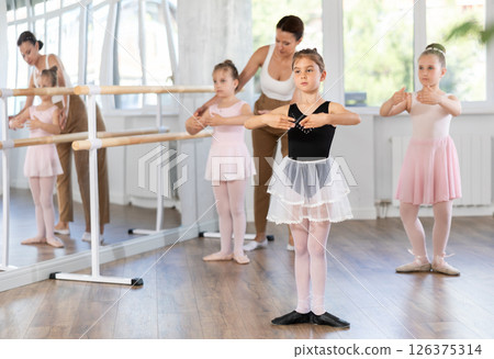 Little girls are learning various dance and ballet movements in studio 126375314