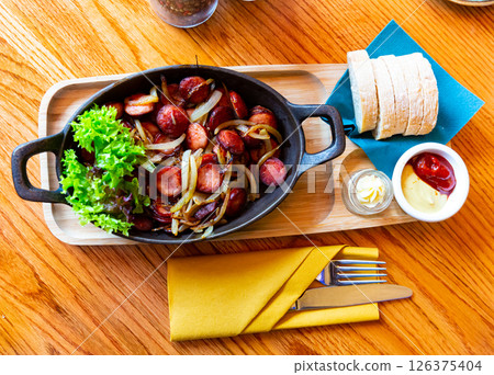 Fried sausages on onions Fried sausages on onions 126375404