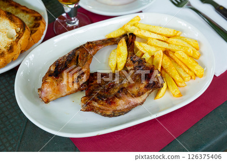 Dish of fried rabbit and French fries. Dish of fried rabbit and French fries. 126375406