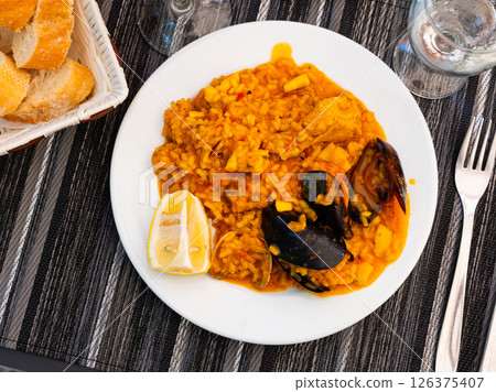 Valencian seafood paella - savory rice dish with shrimps, clams and chicken 126375407