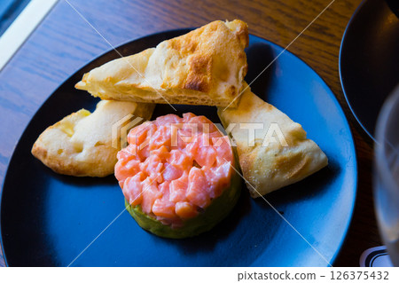 Salmon tartare with guacamole and toasts 126375432
