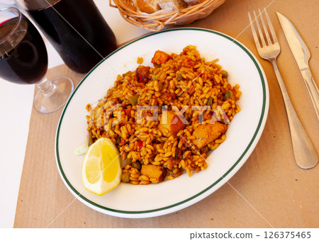Meat paella with lemon on white plate 126375465