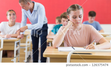 Young students sitting at desks in classroom 126375474