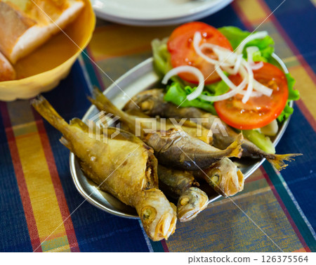 Tasty fried scad served with tomatoes, onion and letucce 126375564