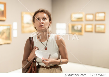 Woman viewing art gallery with brochure 126375608