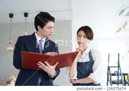 A real estate salesman showing a property and a woman opening a business A real estate salesman showing a property and a woman opening a business 126375674