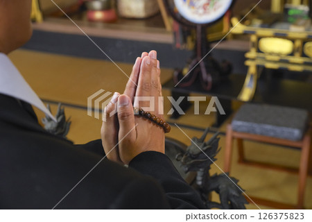 Family members join hands together in prayer to mourn the deceased 126375823