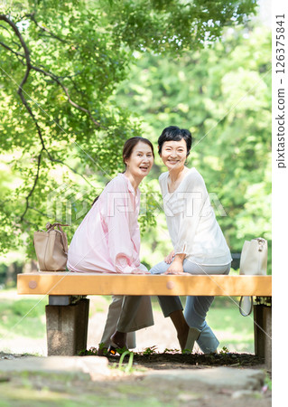 老年婦女在綠樹成蔭的公園聊天 126375841
