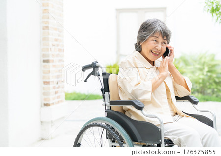 Senior woman in a wheelchair talking on a smartphone 126375855