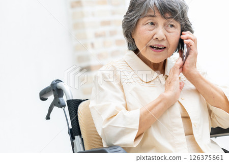 Senior woman in a wheelchair making a phone call 126375861