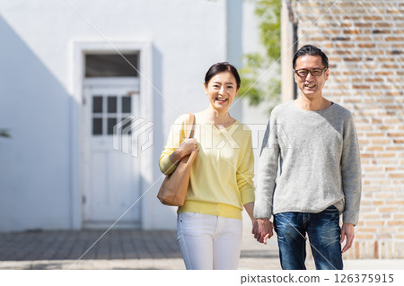 A lively senior couple going out holding hands A lively senior couple going out holding hands 126375915