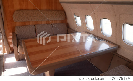 Elegant vintage USSR aircraft interior with polished wood, comfy seating, and large windows, showcasing the luxury of early Russian air travel. 126376159