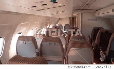 Inside a Soviet-era aircraft with vintage design, the cabin features empty rows of seating, illustrating the unique travel experience in Russia's aviation history. 126376175