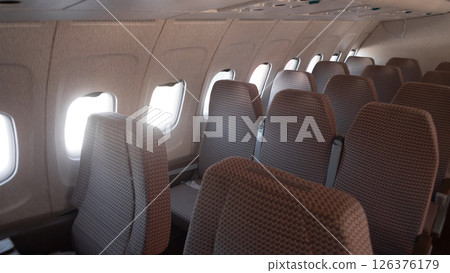 Inside a vintage Soviet airplane, rows of patterned seats align with windows, revealing a nostalgic glimpse of air travel in Russia during the USSR era. 126376179