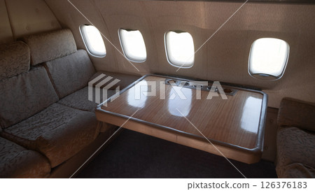 This vintage USSR aircraft interior features plush seating and an elegant wooden table, reflecting the luxury of air travel in Russia during the Soviet era. This vintage USSR aircraft interior features plush seating and an elegant wooden table, reflecting the luxury of air travel in Russia during the Soviet era. 126376183