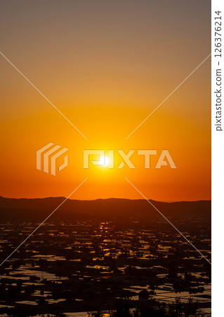 [A magnificent view in early summer] Sunset in the Tonami Plain and scattered villages in early summer and reflections in the rice fields [Toyama Prefecture] 126376214