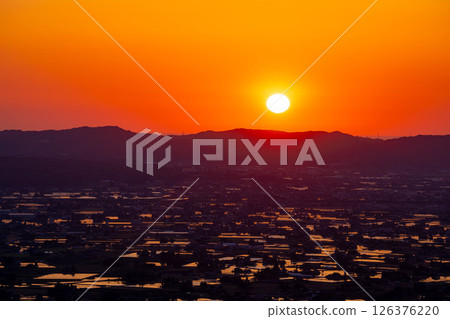 [A magnificent view in early summer] Sunset in the Tonami Plain and scattered villages in early summer and reflections in the rice fields [Toyama Prefecture] 126376220