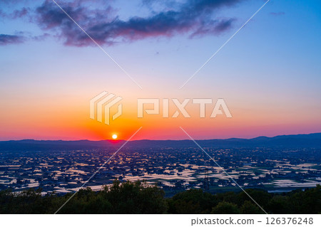 [A magnificent view in early summer] Sunset in the Tonami Plain and scattered villages in early summer and reflections in the rice fields [Toyama Prefecture] 126376248