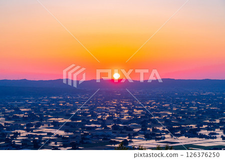 [A magnificent view in early summer] Sunset in the Tonami Plain and scattered villages in early summer and reflections in the rice fields [Toyama Prefecture] 126376250