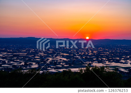 [A magnificent view in early summer] Sunset in the Tonami Plain and scattered villages in early summer and reflections in the rice fields [Toyama Prefecture] 126376253