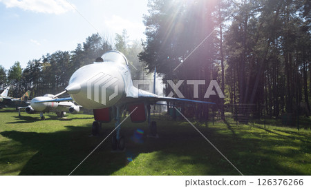 A Soviet fighter jet stands prominently in a wooded area, highlighting its design and historical significance during the Cold War. A Soviet fighter jet stands prominently in a wooded area, highlighting its design and historical significance during the Cold War. 126376266