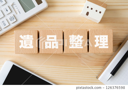 A block with the words "sorting belongings" written on it, a calculator, and a model of a house A block with the words "sorting belongings" written on it, a calculator, and a model of a house 126376598