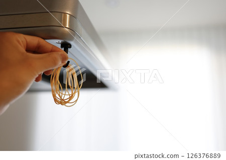 Many rubber bands hanging from a range hood Many rubber bands hanging from a range hood 126376889