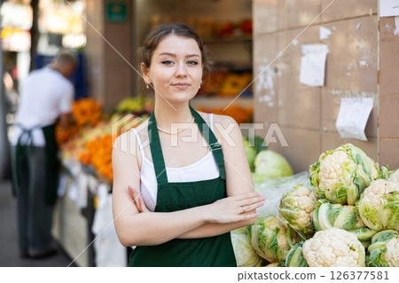 Woman Seller Smiling Against Vegetable Stall Background Woman Seller Smiling Against Vegetable Stall Background 126377581