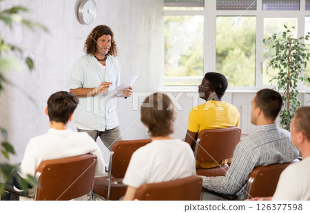 Middle-aged man teacher reading lecture for a group of guys 126377598