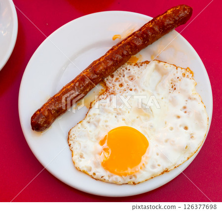 Fried eggs served with chistorra sausages 126377698