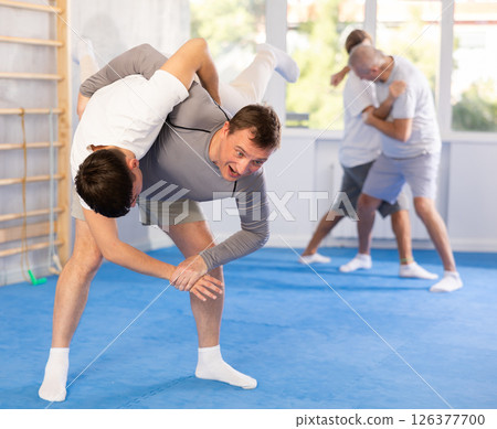 Two men training judo technique in studio Two men training judo technique in studio 126377700