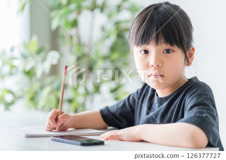 在家學習的小學生。 在家學習的小學生。 126377727