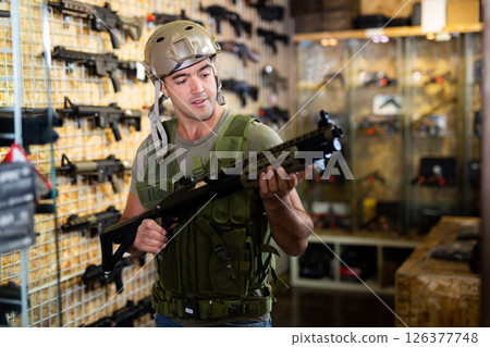 Man in army uniform with weapon in military market Man in army uniform with weapon in military market 126377748