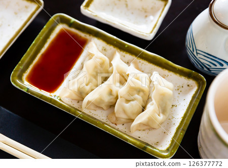 Steamed dumplings gyoza with meat filling served with sauce Steamed dumplings gyoza with meat filling served with sauce 126377772