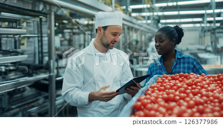 Factory Manager Collaborates with Migrant Worker Using Tablet Technology on the Production Floor. Generated image 126377986