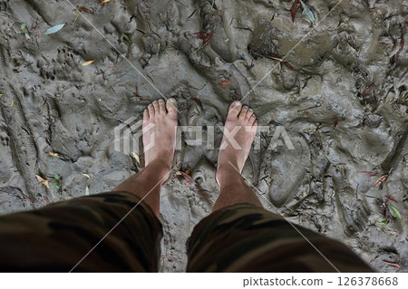 Barefoot man standing in the mud 126378668