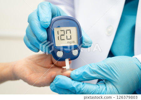 Asian doctor using digital glucose meter for check sample blood sugar level to treatment diabetes. Asian doctor using digital glucose meter for check sample blood sugar level to treatment diabetes. 126379803