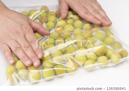 用小李子製作脆李子的步驟 將預先處理好的小李子和鹽放入密封袋中，用手滾動。 126380841