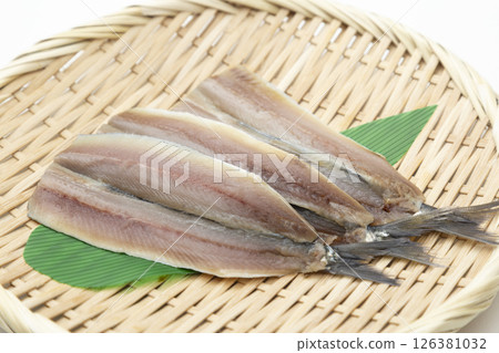 Opened sardines in a basket on a white background Opened sardines in a basket on a white background 126381032